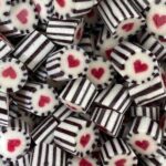 Black and white striped outer wrap candy with pink centered love heart, nectarine flavour.